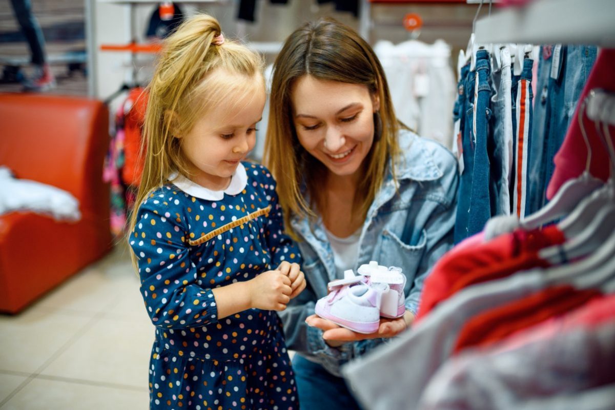 Mother and little baby buying clothes, kid's store